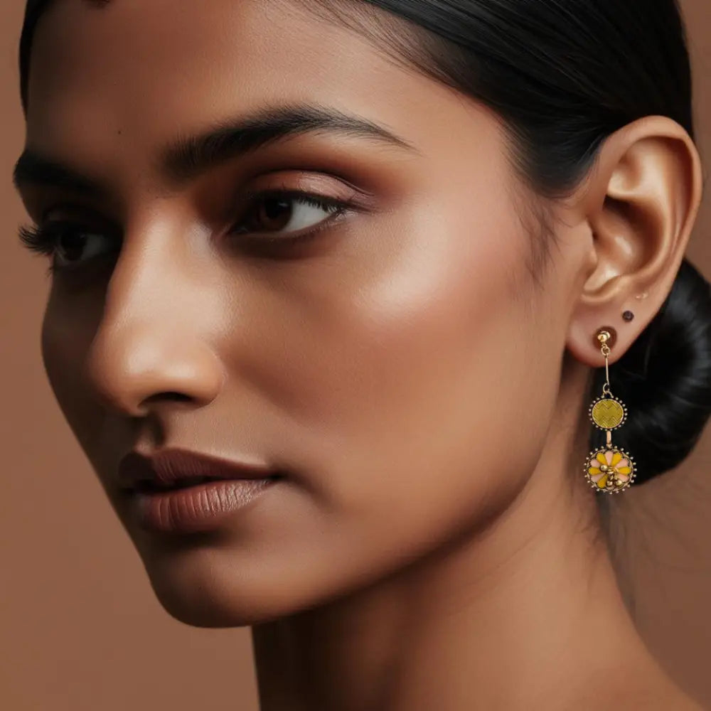 Yellow and pink enamel floral earrings with antique gold finish, featuring intricate detailing and ghungroo charms, perfect for festive and ethnic wear