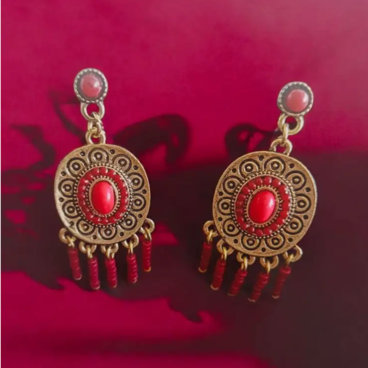 Antique gold and red dangle earrings with tribal-inspired patterns, intricate detailing, and beaded fringes, perfect for boho-chic and festive wear.
